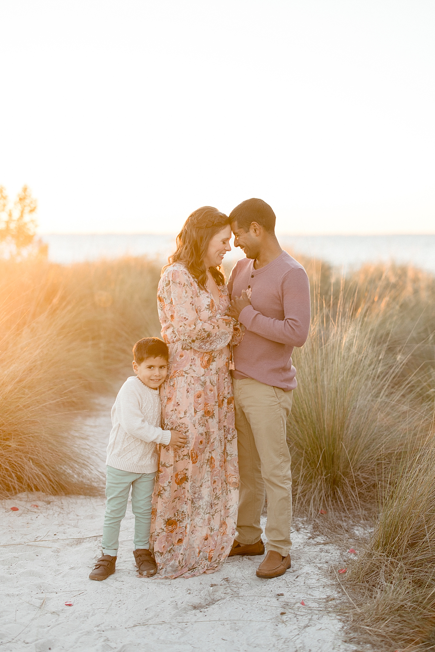 Mom and Dad looking at each other with son standing beside them. Photo by Brittany Elise Photography.