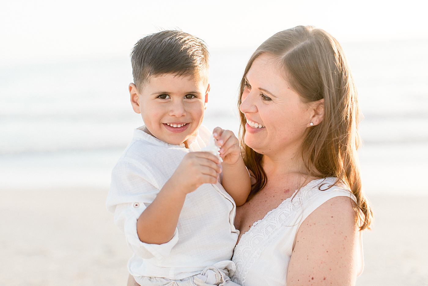 Mom smiling at son during family beach session with Brittany Elise Photography.