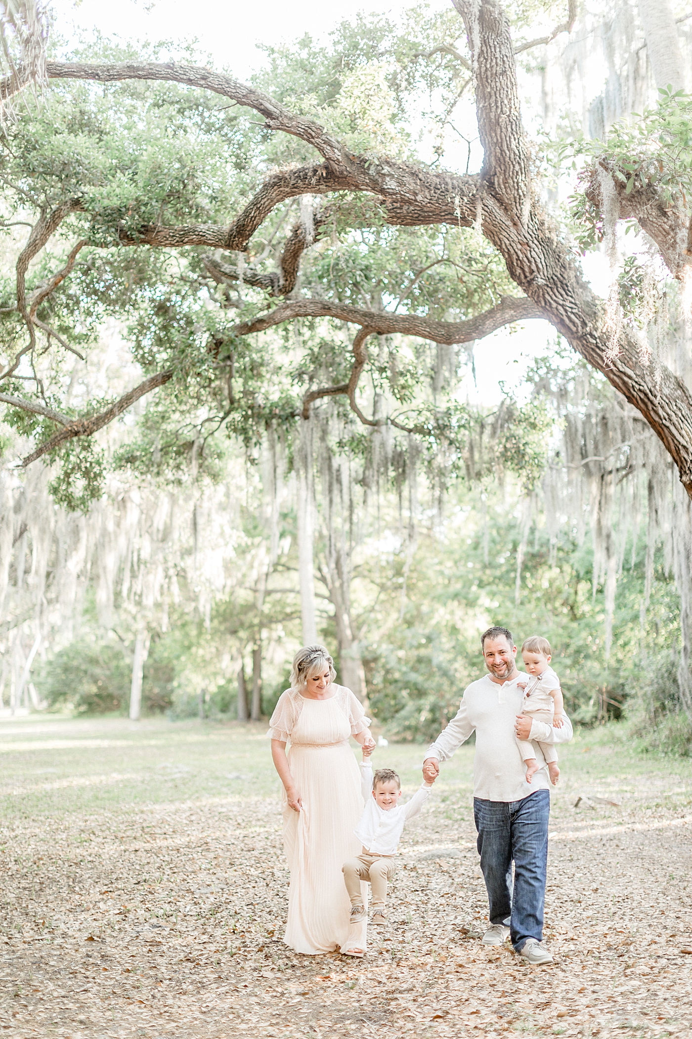 Family walking under Oaks with Spanish Moss. Photo by Brittany Elise Photography.