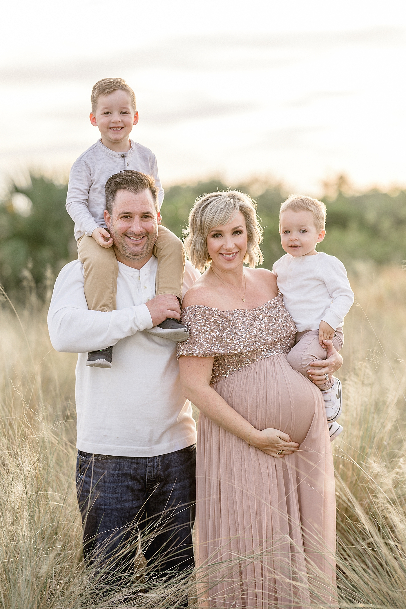 Family portrait with Mom holding one son and the other on Dad's shoulders. Photo by Brittany Elise Photography.
