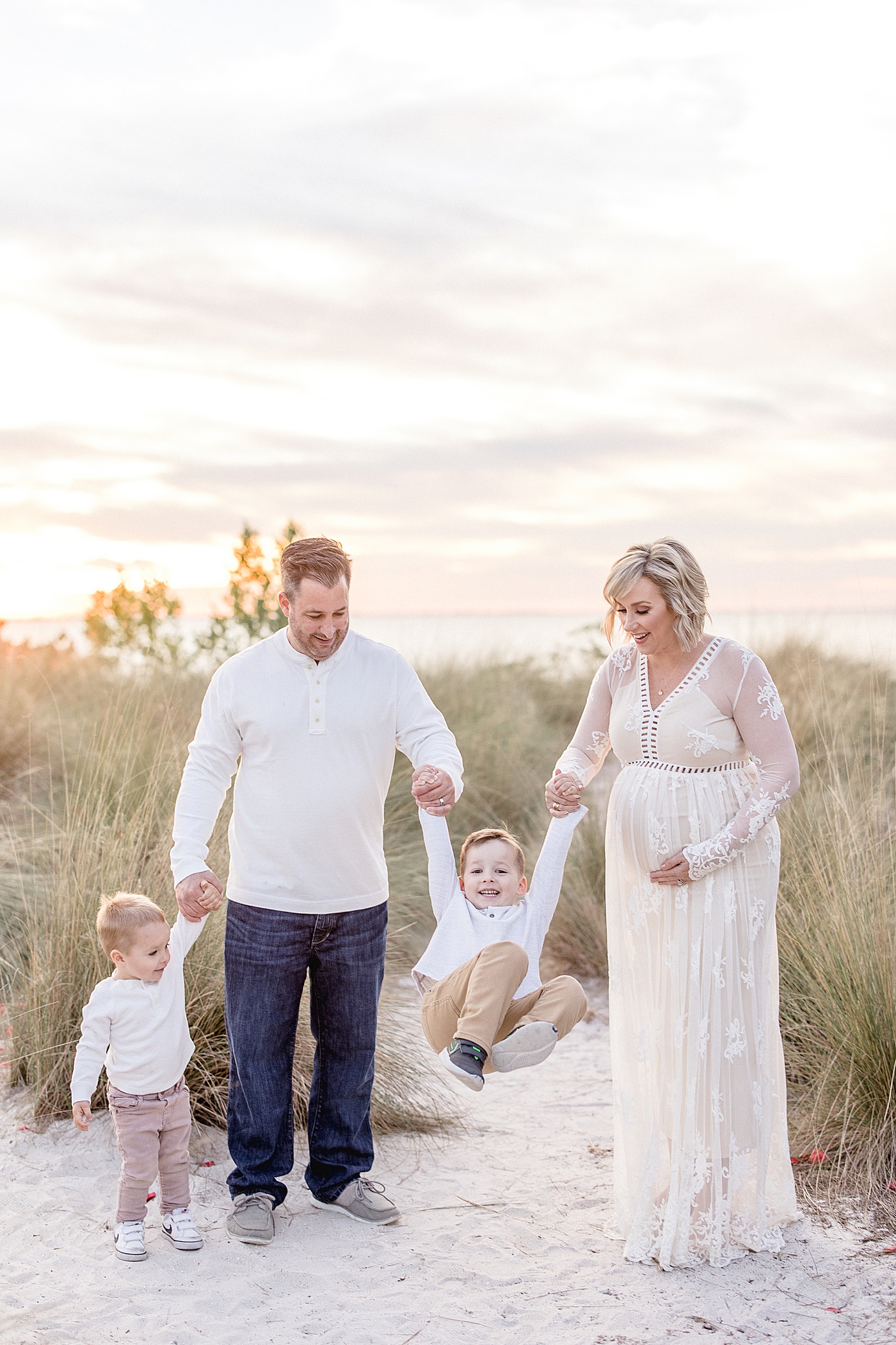 Family walking and swinging one son while the other looks at him. Photo by Brittany Elise Photography.