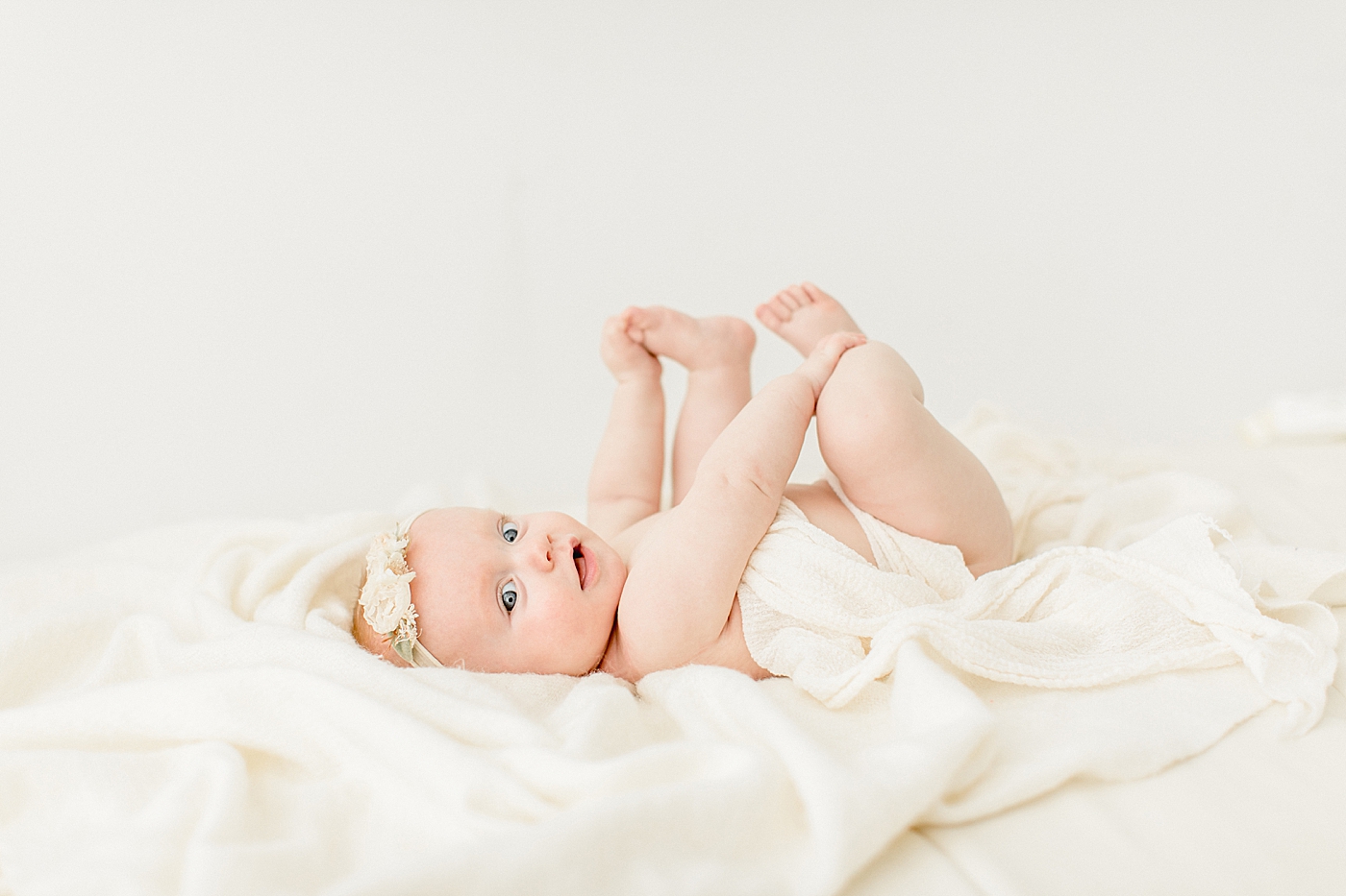 Baby grabbing her toes during milestone photoshoot with Brittany Elise Photography.