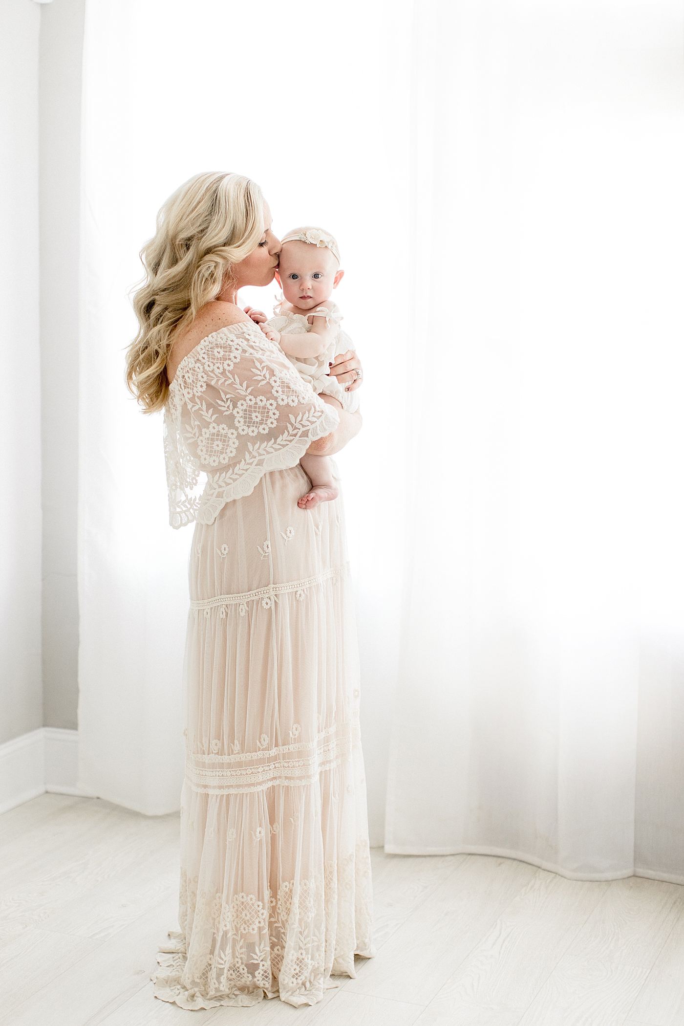 Mom and baby girl together in front of beautiful window. Photo by Tampa Photographer, Brittany Elise Photography.