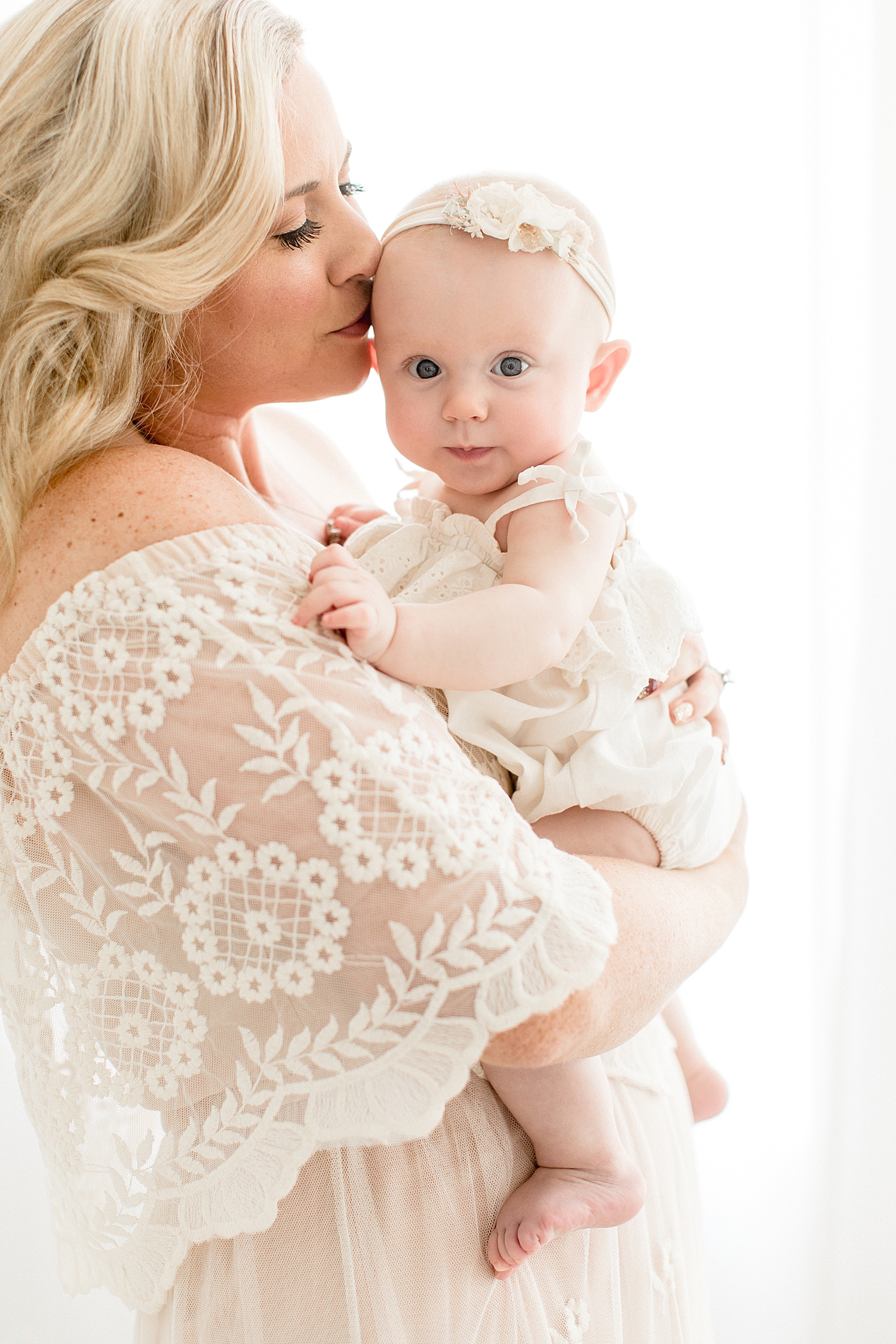 Mom giving her baby girl a kiss. Photo by Brittany Elise Photography.