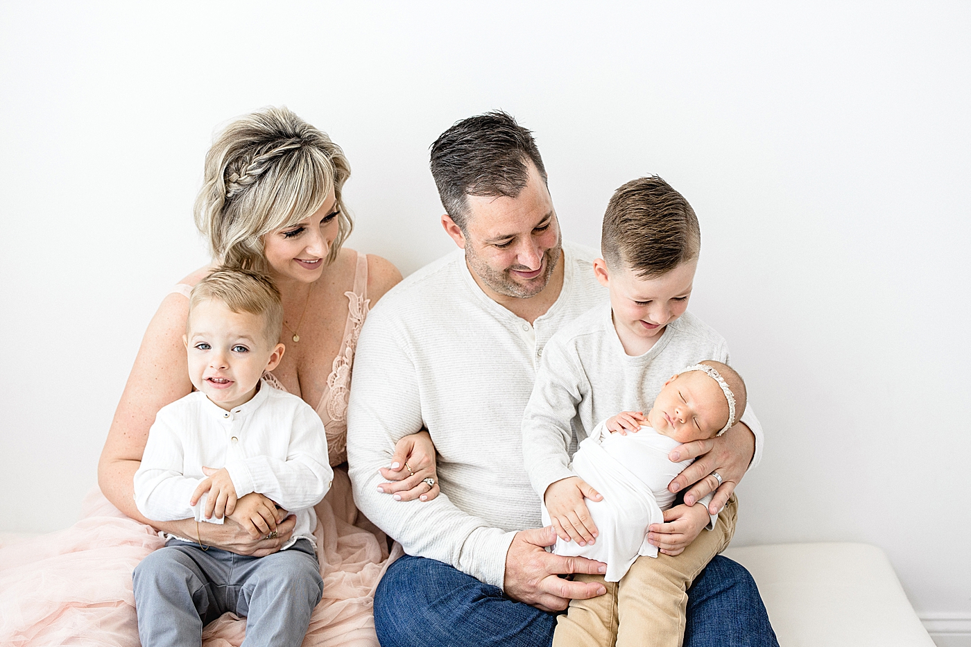 Family portrait with Mom, Dad, two boys and baby sister during baby girl's newborn session in the studio with Brittany Elise Photography.
