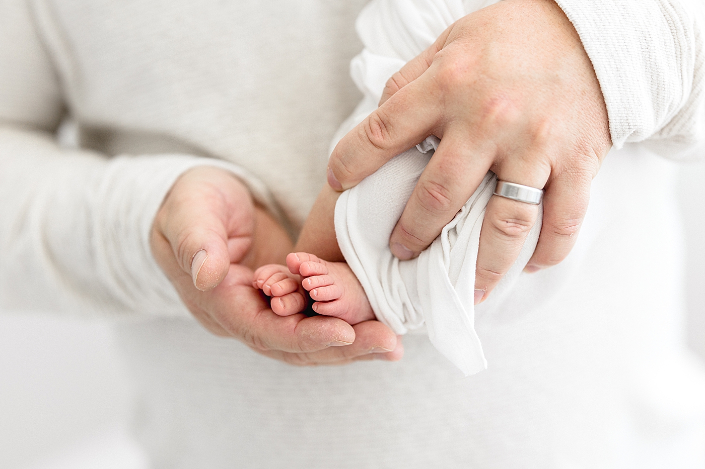 Tiny baby toes in Dad's hands. Photo by Brittany Elise Photography.