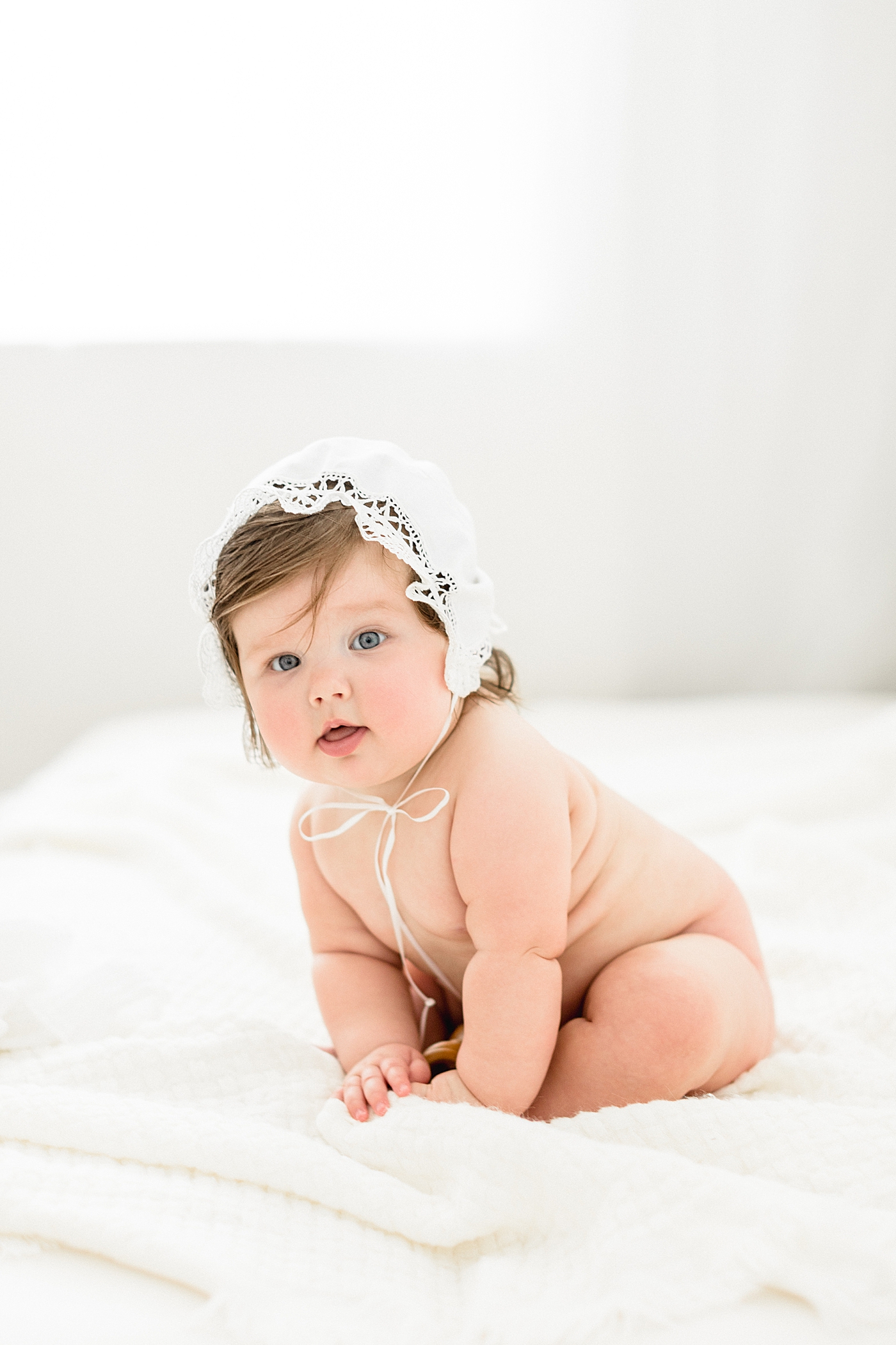 Six month old baby girl wearing a bonnet for milestone session. Photo by Brittany Elise Photography.