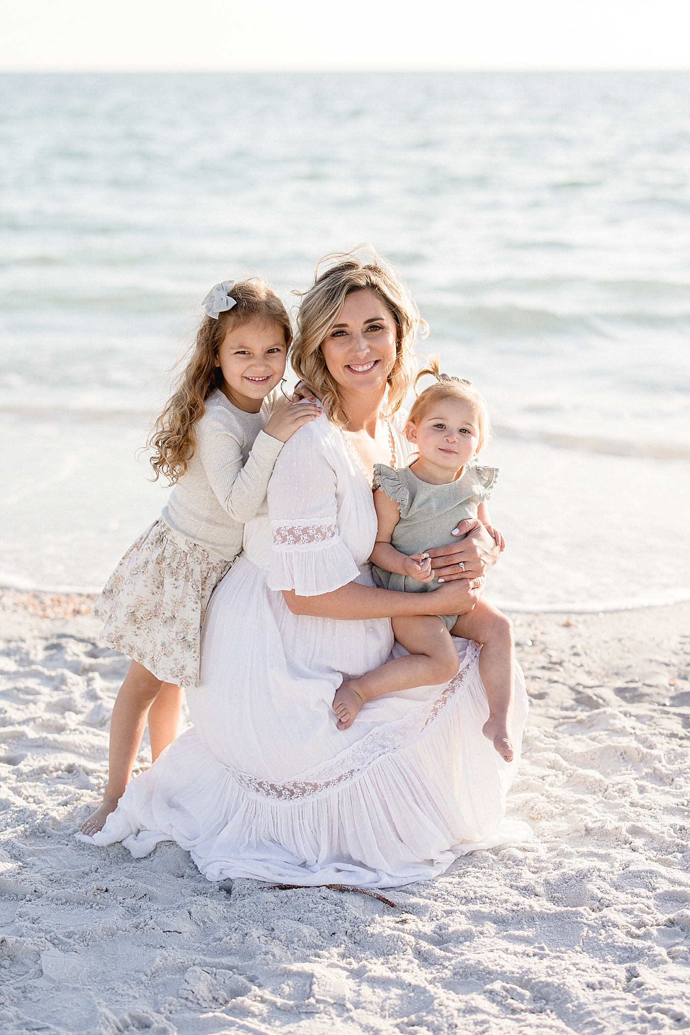 Sunset portrait of Mom and her two daughters. Photo by Brittany Elise Photography.