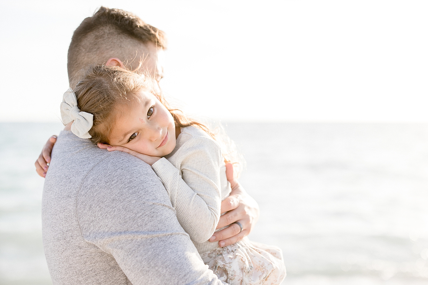 Daughter hugging her daddy on the beach for family photoshoot with Brittany Elise Photography.