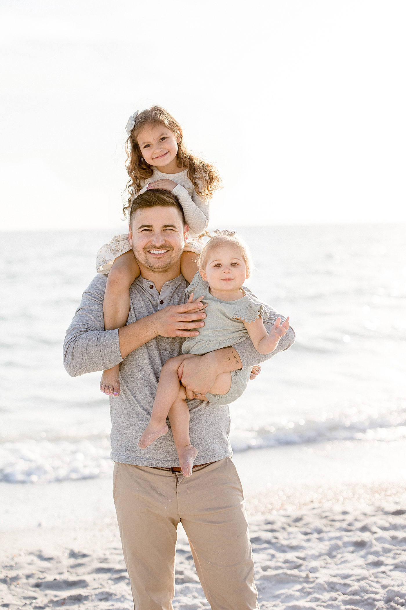 Father holding his girls on the beach for photos with Tampa Photographer, Brittany Elise Photography.