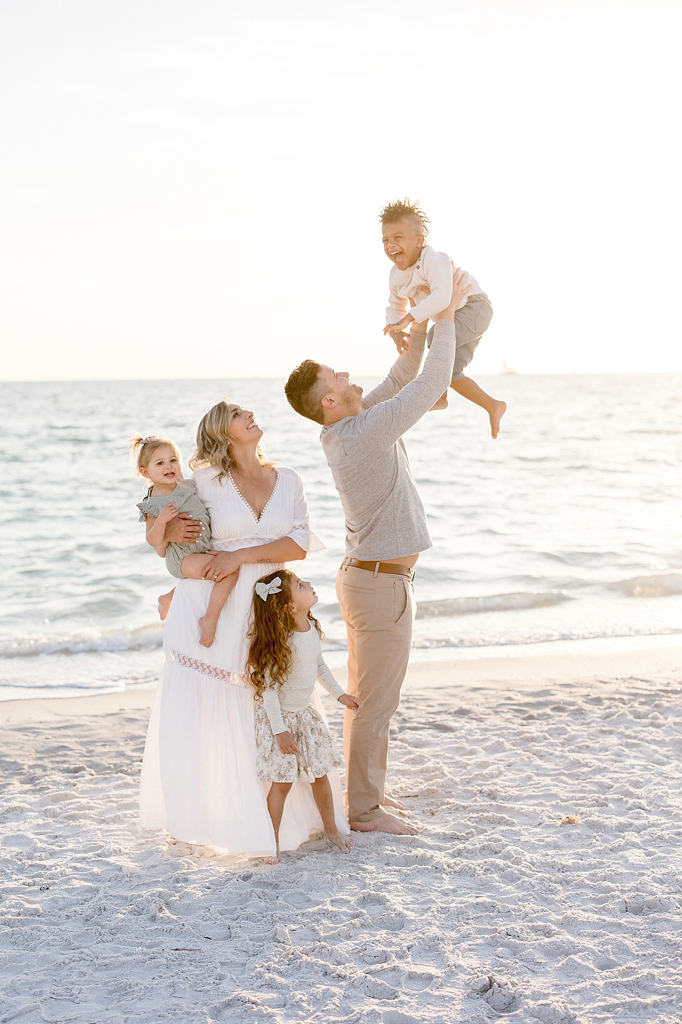 Dad playing airplane with son and rest of family looking at him! Photo by Brittany Elise Photography.