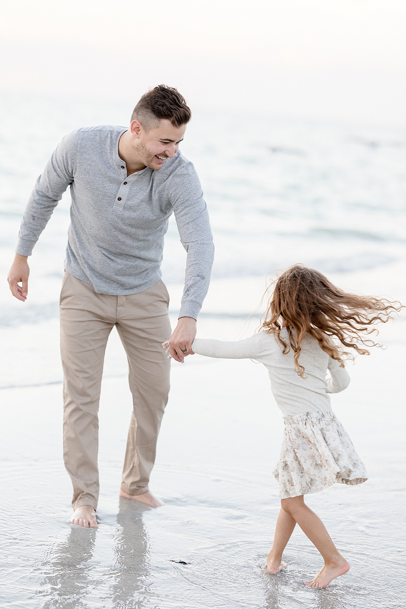 Dad dancing with his daughter on the beach. Photo by Brittany Elise Photography.