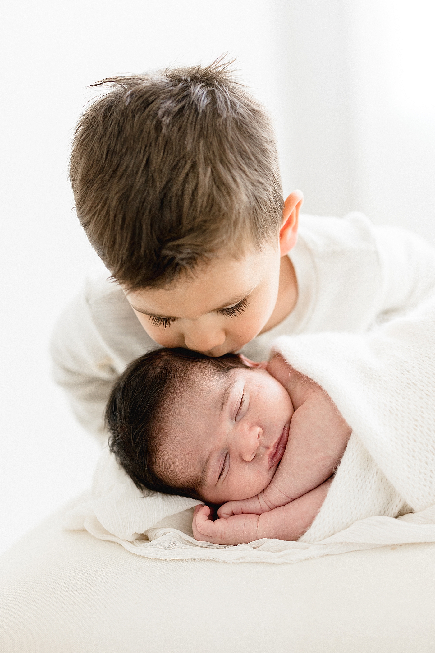 Big brother giving his baby brother a kiss. Photo by Brittany Elise Photography.