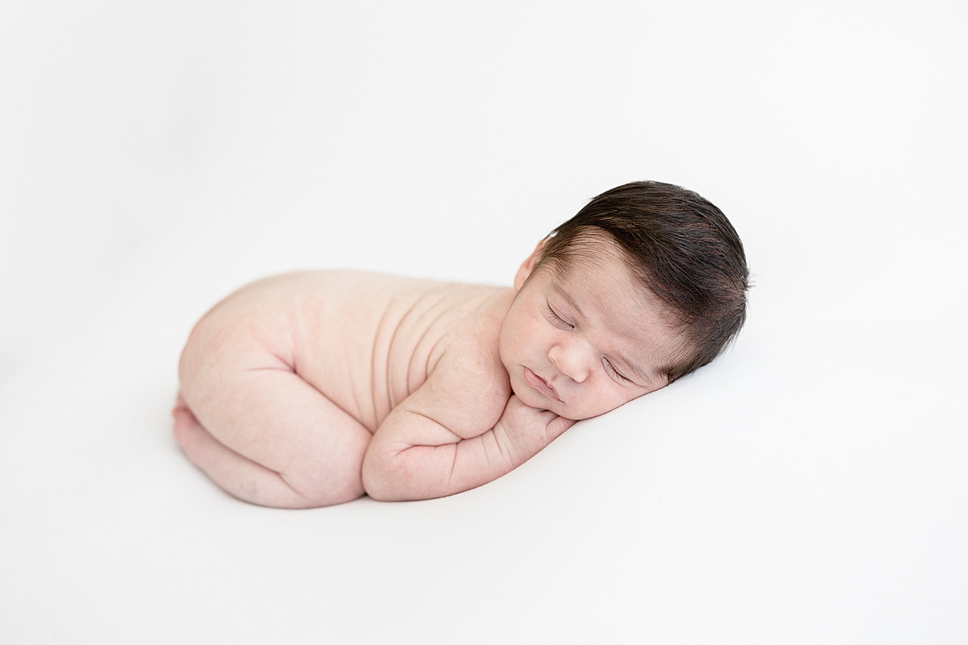 Baby posed on his belly for newborn photos. Photo by Brittany Elise Photography.