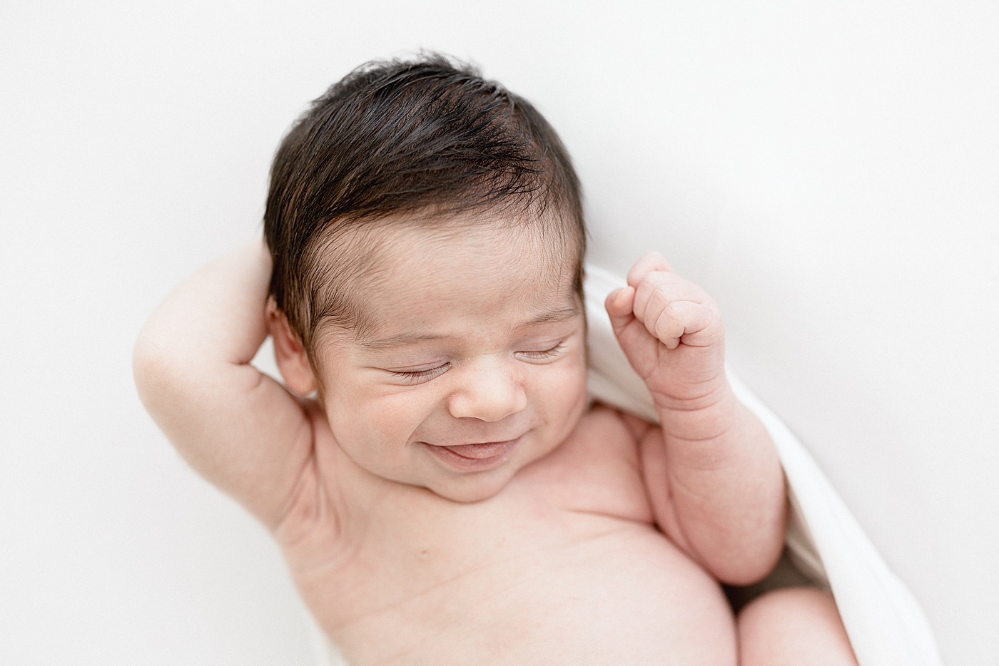 Baby smiling during newborn photos in Tampa photography studio. Photo by Brittany Elise Photography.