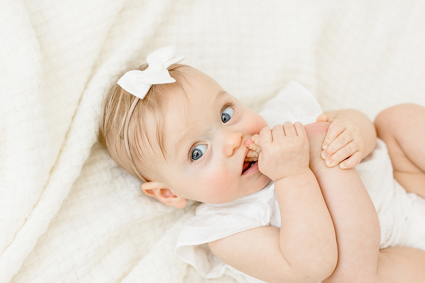 Tampa baby photographer, Brittany Elise, photographs six month old little girl eating her toes! 