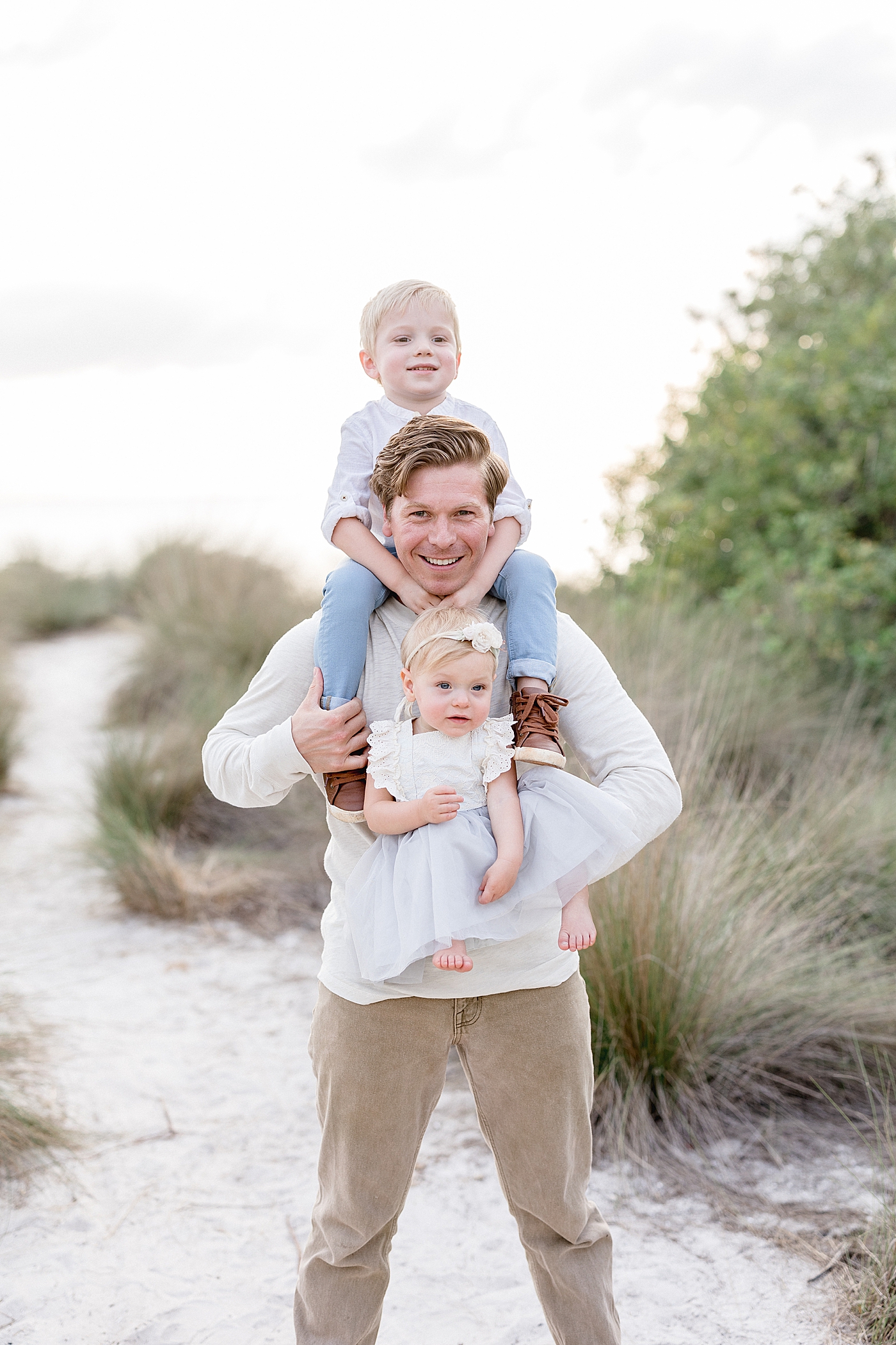 Dad holding both of his children for a photo at Cypress Point Park. Photo by Brittany Elise Photography.