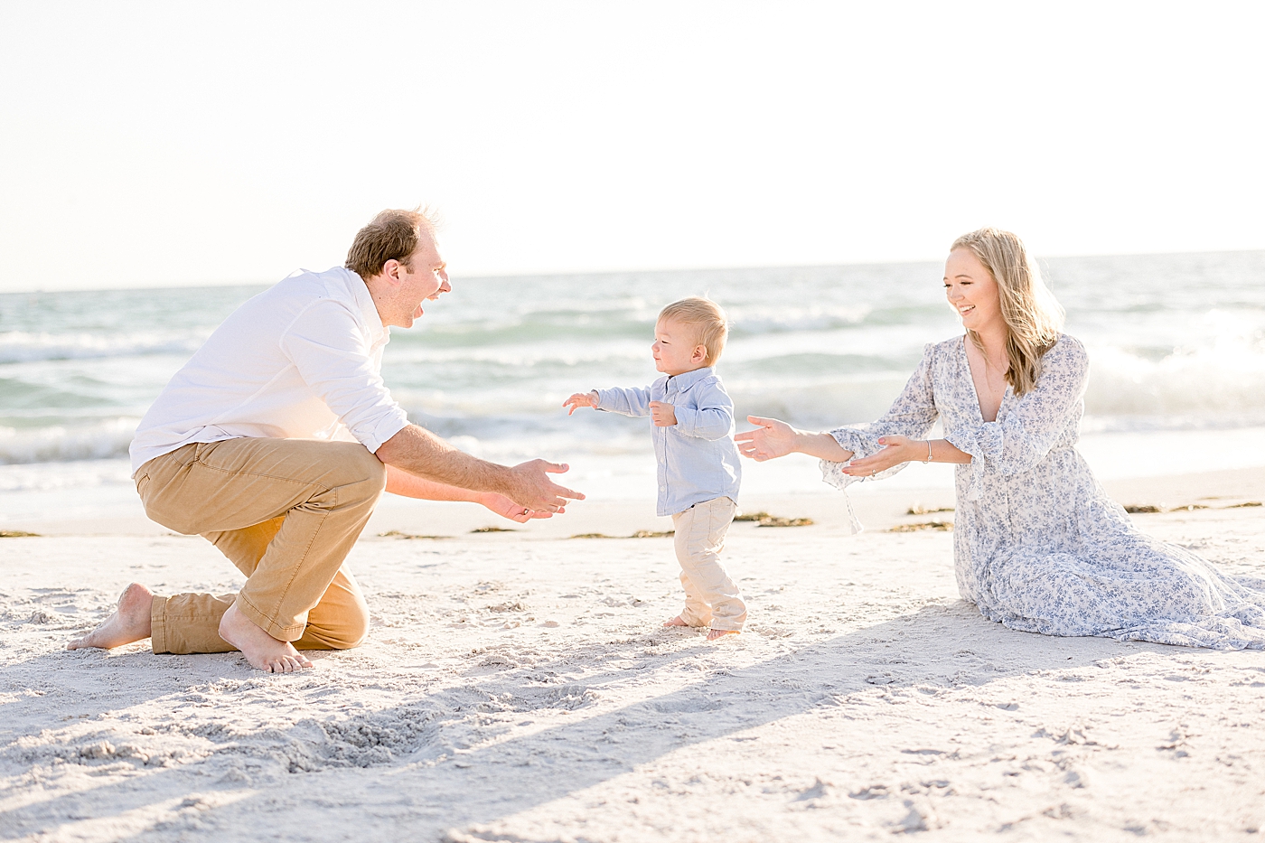 Family photos on the beach. Toddler son is walking towards his Dad. Photo by Brittany Elise Photography.