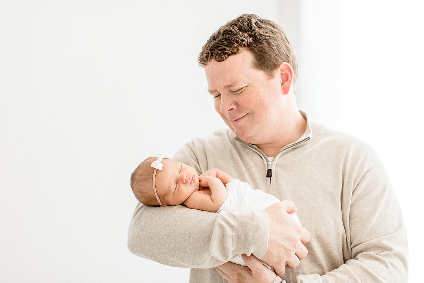 Dad holding his daughter during newborn session. Photo by Brittany Elise Photography.