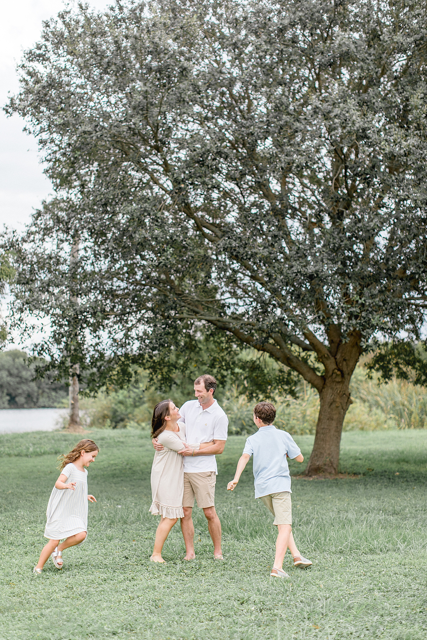 Two kids running around Mom and Dad during family photoshoot. Photo by Brittany Elise Photography.
