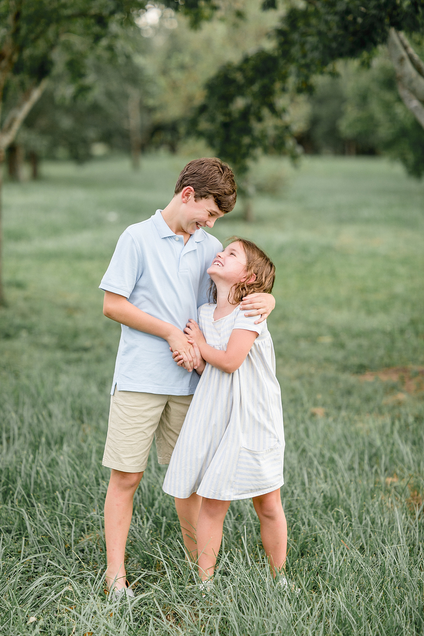 Brother and sister hugging and looking at each other during family photoshoot. Photo by Brittany Elise Photography.