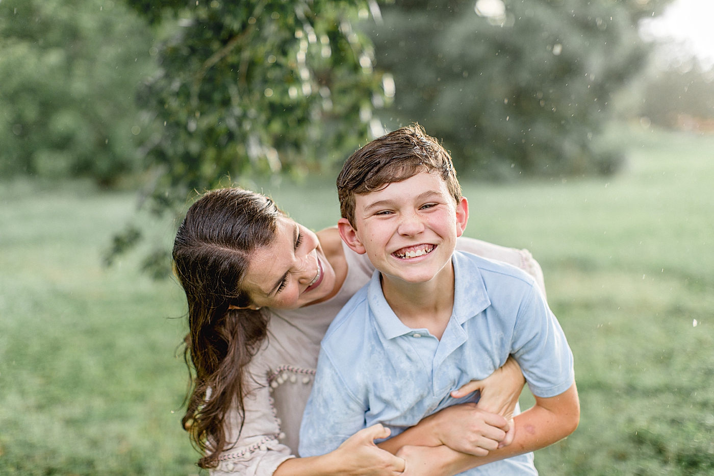 Mom hugging her son and playing in the rain during family photos with Brittany Elise Photography.