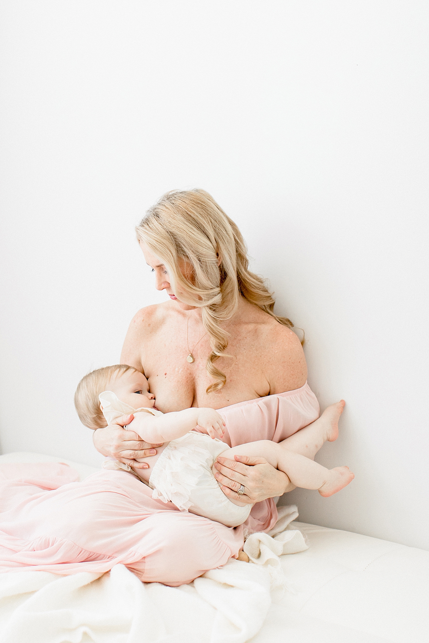 Breastfeeding photo of Mom and her baby girl in studio with Brittany Elise Photography.