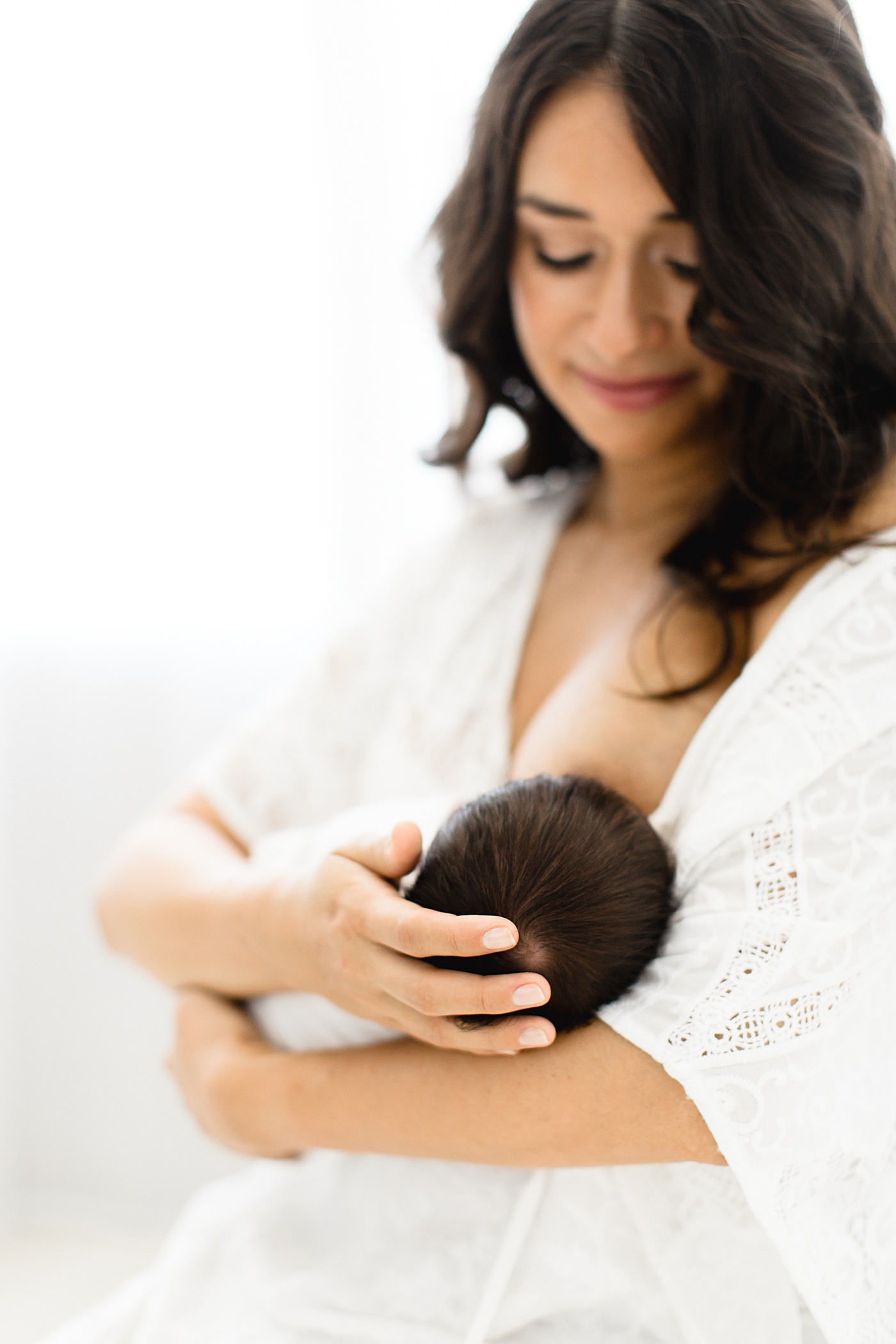 Mom breastfeeding her baby in studio with Brittany Elise Photography.