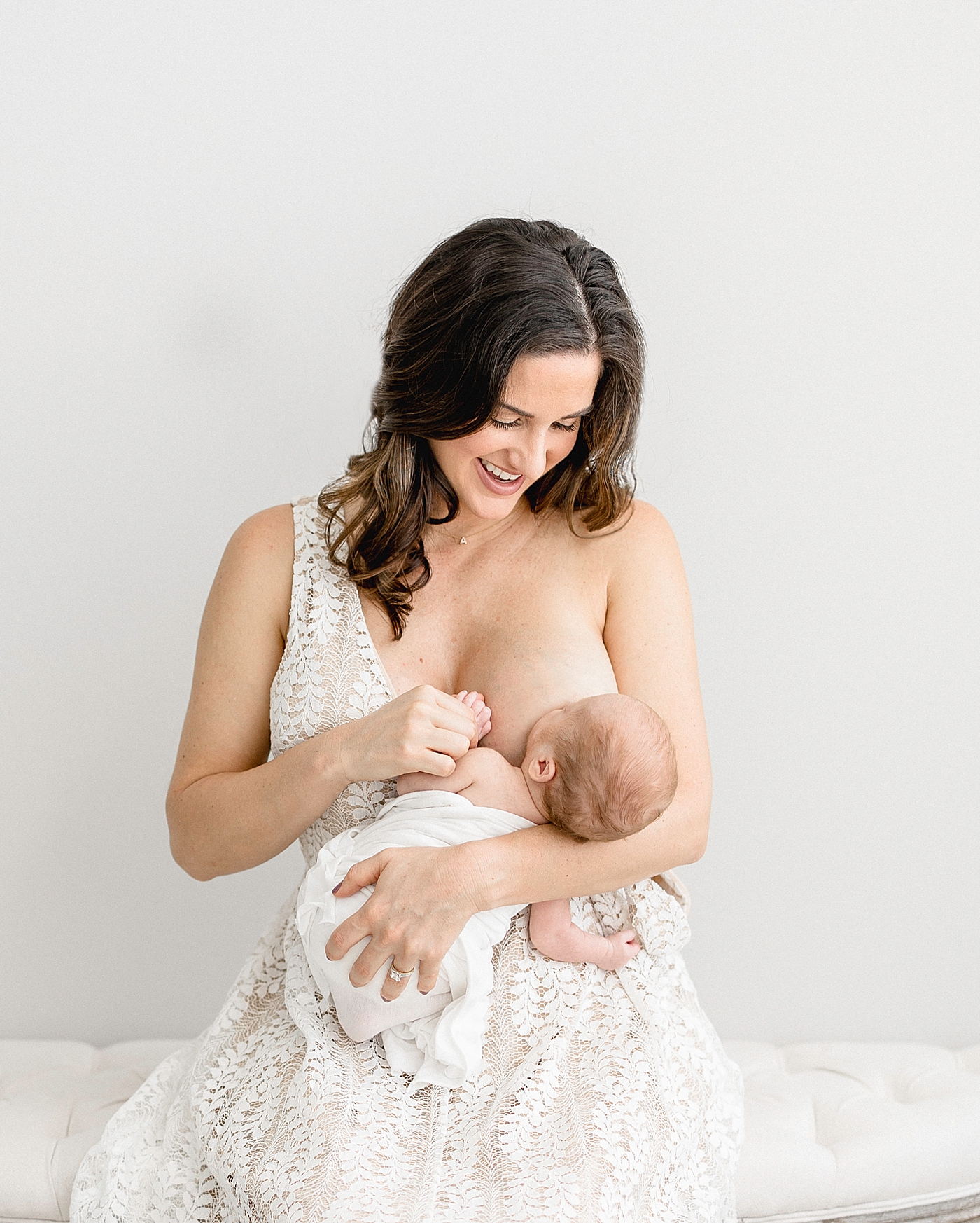 Mom holding her baby and breastfeeding during newborn session. Photo by Brittany Elise Photography.