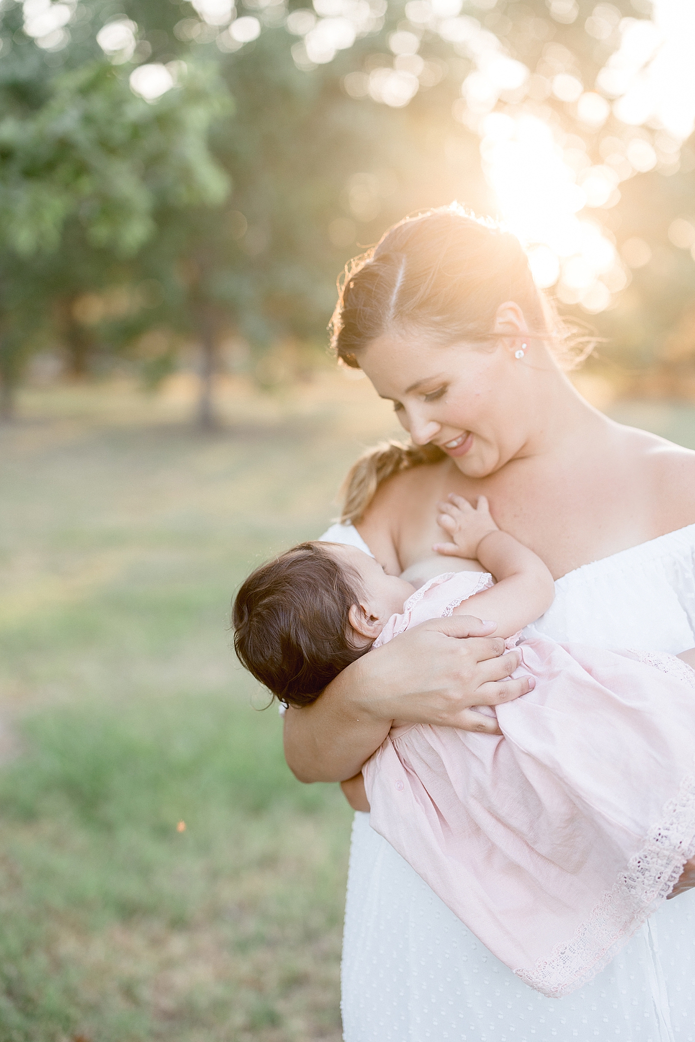 Mom breastfeeding her daughter during sunset family in session in Tampa. Photo by Brittany Elise Photography.