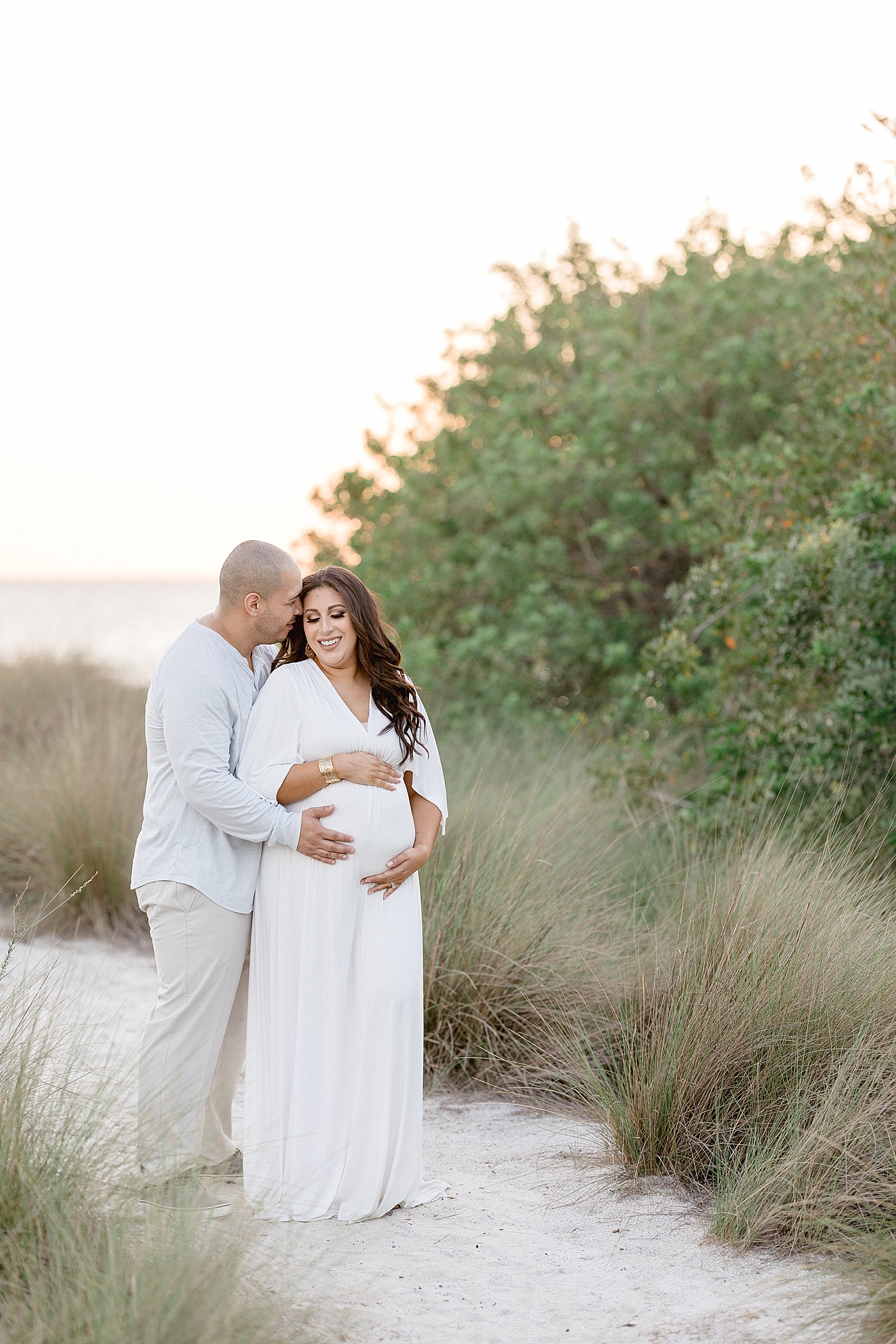 Couple sharing a sweet moment during maternity session at Cypress Point Park. Photo by Brittany Elise Photography.