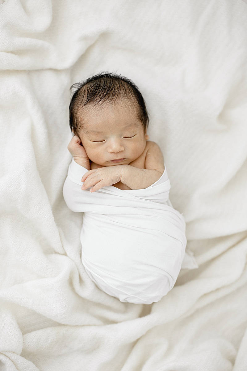 Baby boy swaddled in white. Photo by Brittany Elise Photography.
