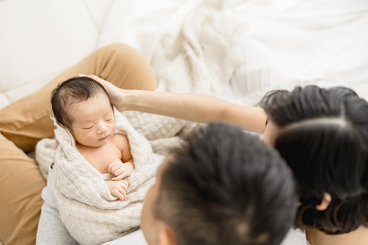 First-time parents holding their son for newborn photos with Brittany Elise Photography.