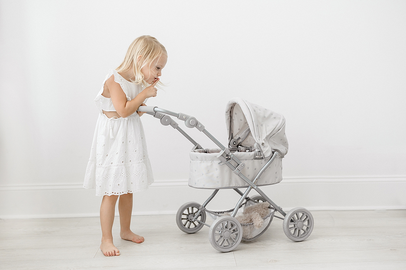 Young girl with pram stroller. Photo by Brittany Elise Photography.