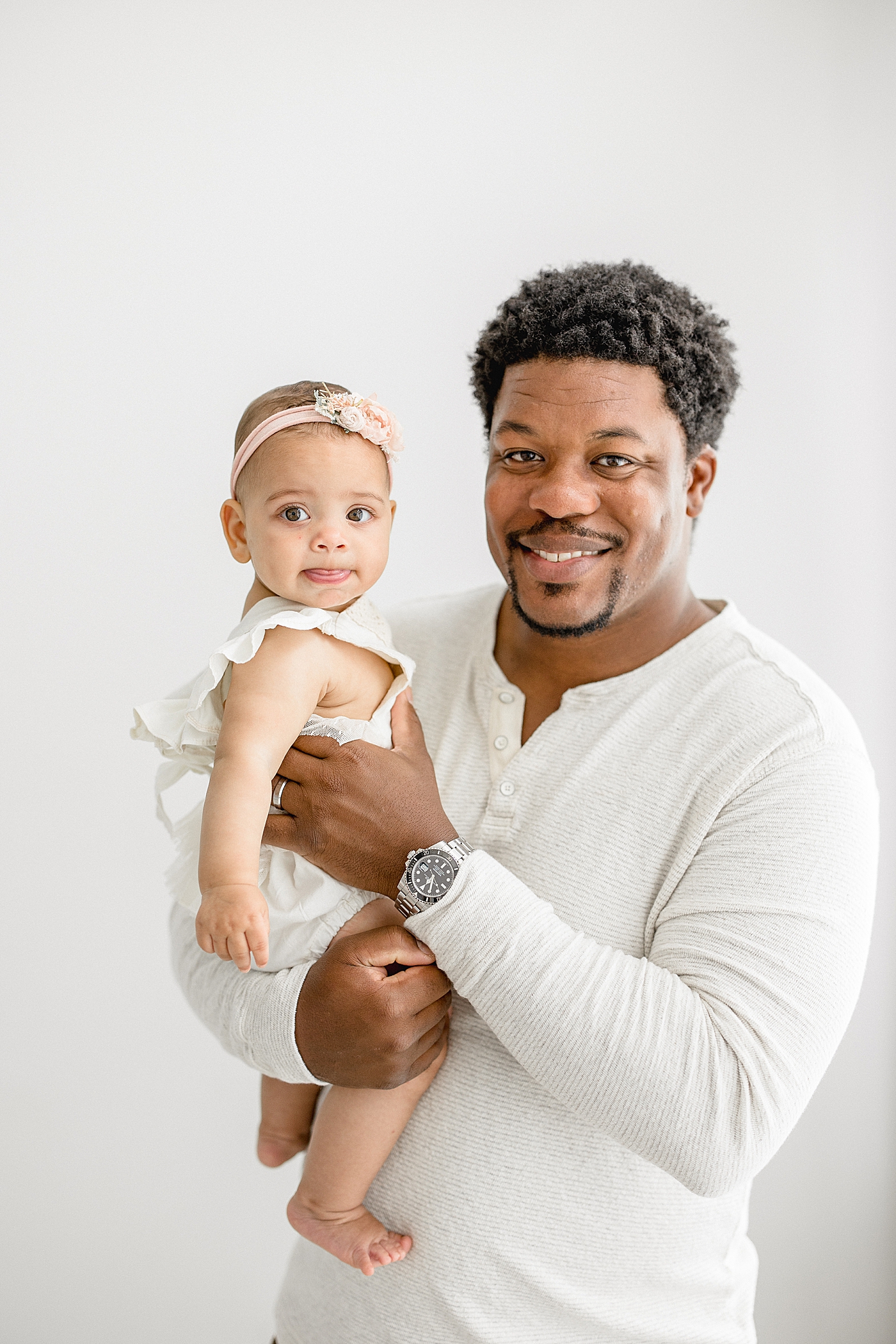 Dad holding his baby girl for her six month photos. Photo by Brittany Elise Photography.
