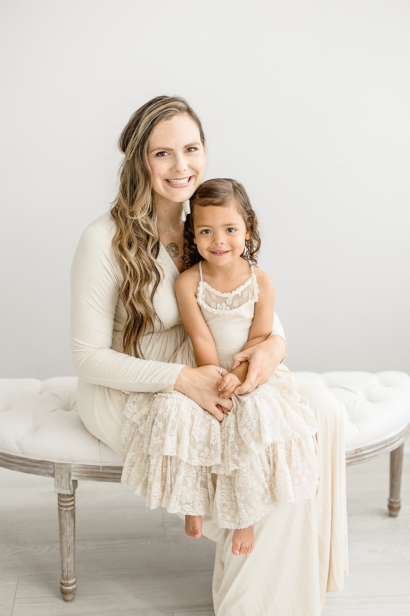 Mom and her oldest daughter sitting on a bench. Photo by Brittany Elise Photography.