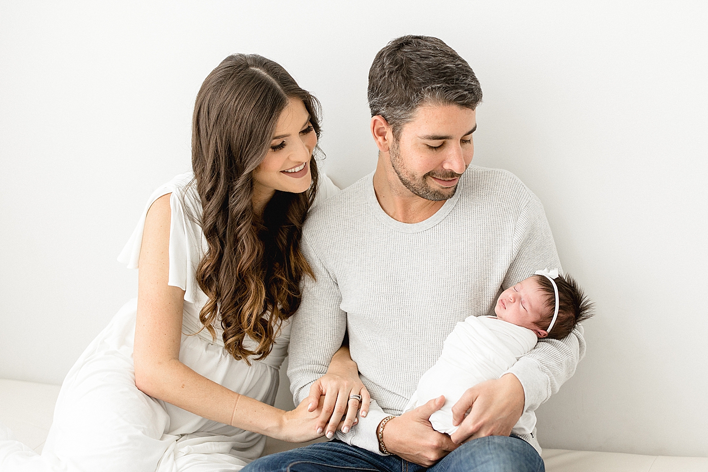 Parents looking at their newborn daughter. Photos by Brittany Elise Photography.