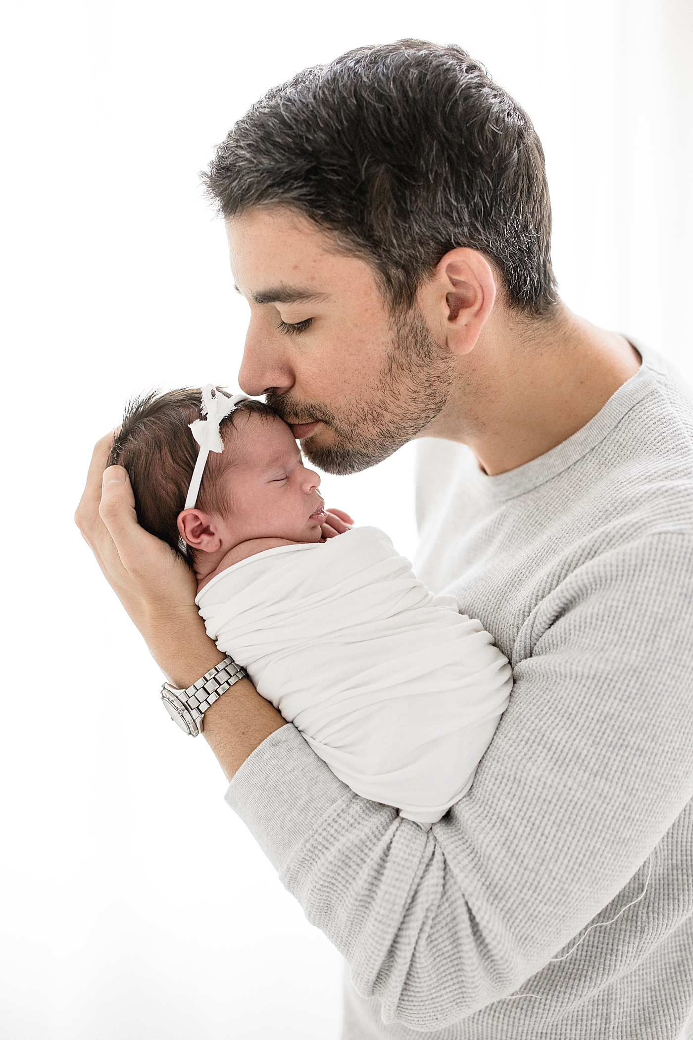 Dad giving daughter a kiss on the forehead. Photos by Brittany Elise Photography.