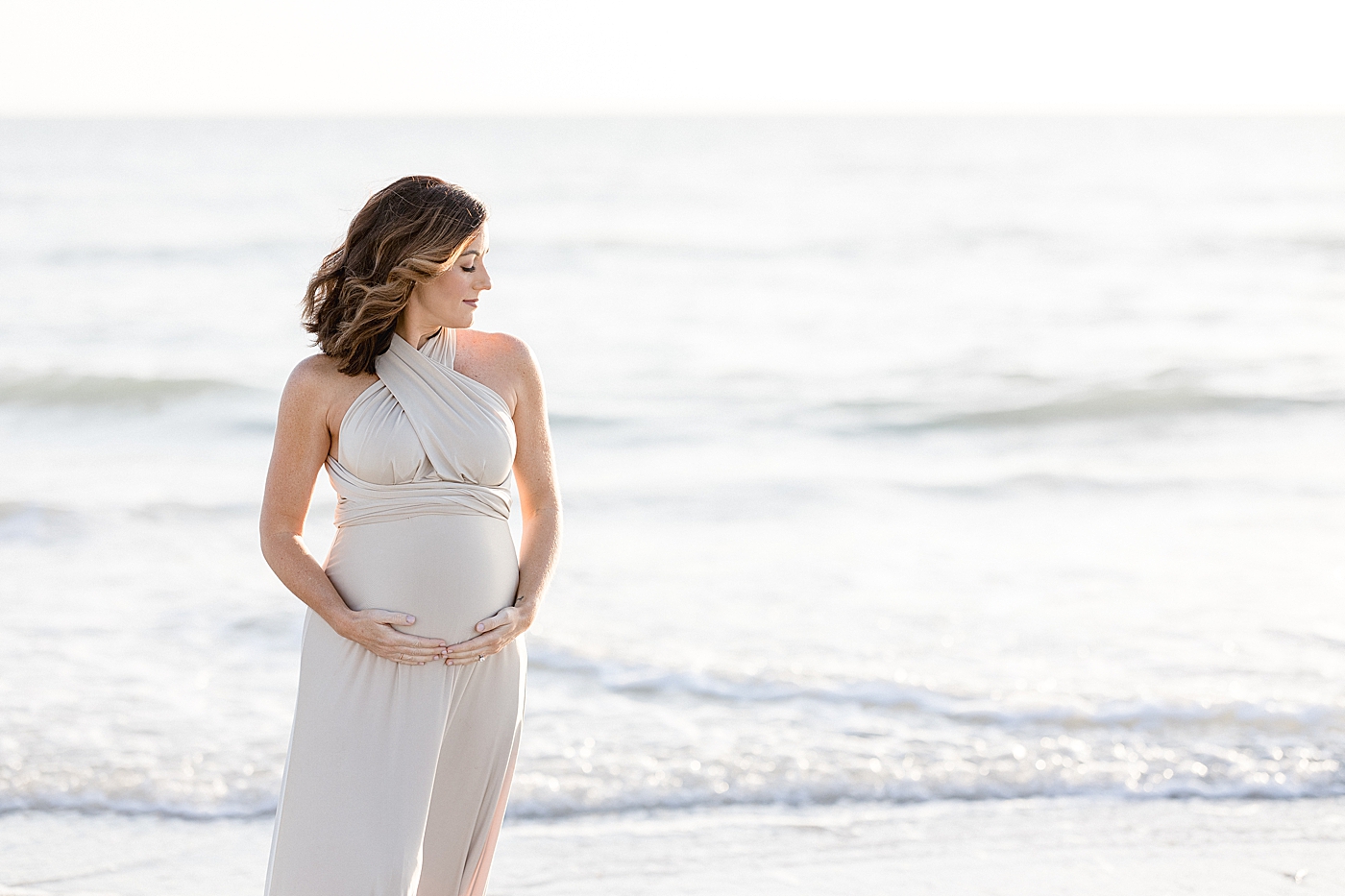 Expecting mom holding belly. Photo by Brittany Elise Photography.