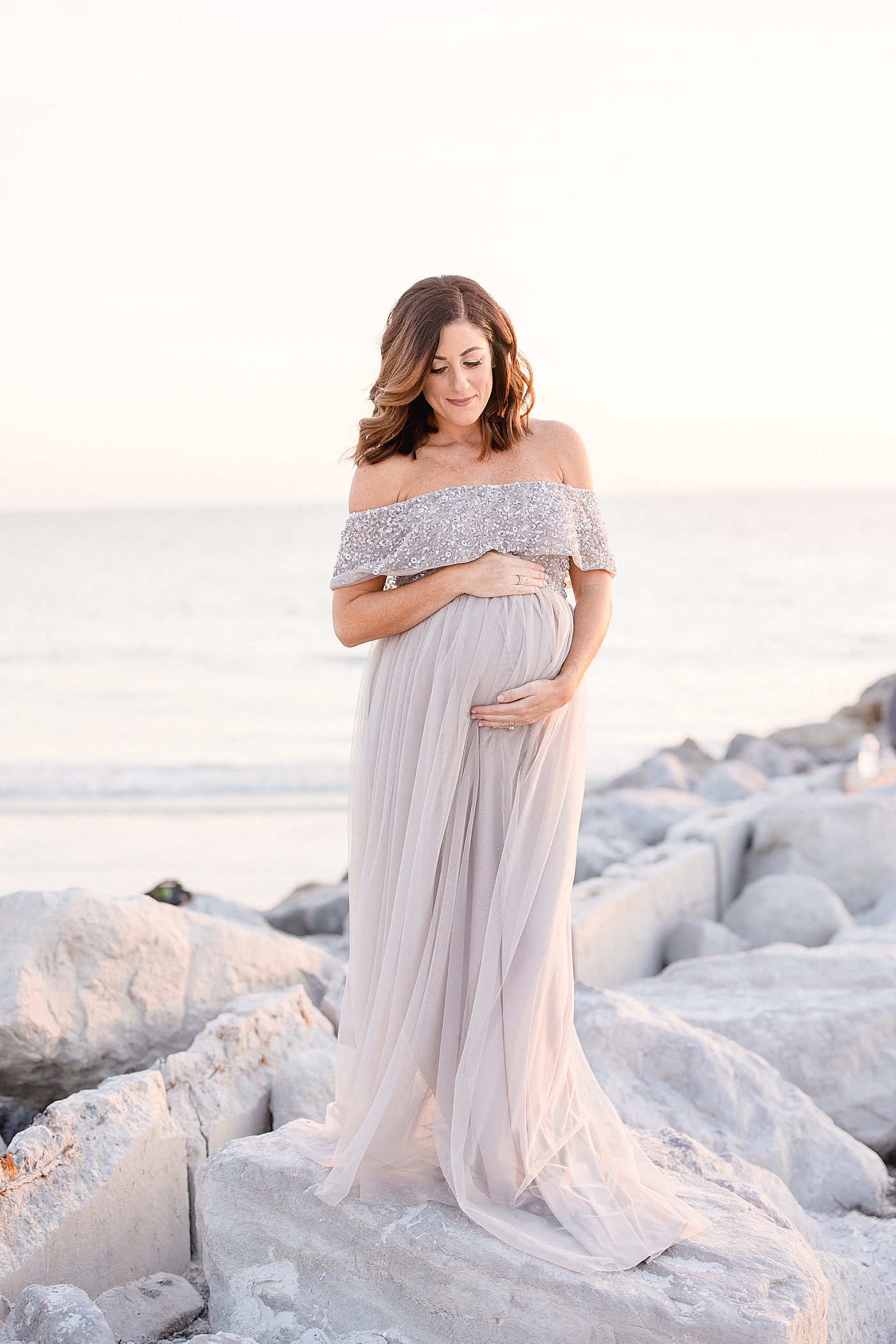 Mom standing on rocks at maternity session. Photo by Brittany Elise Photography.