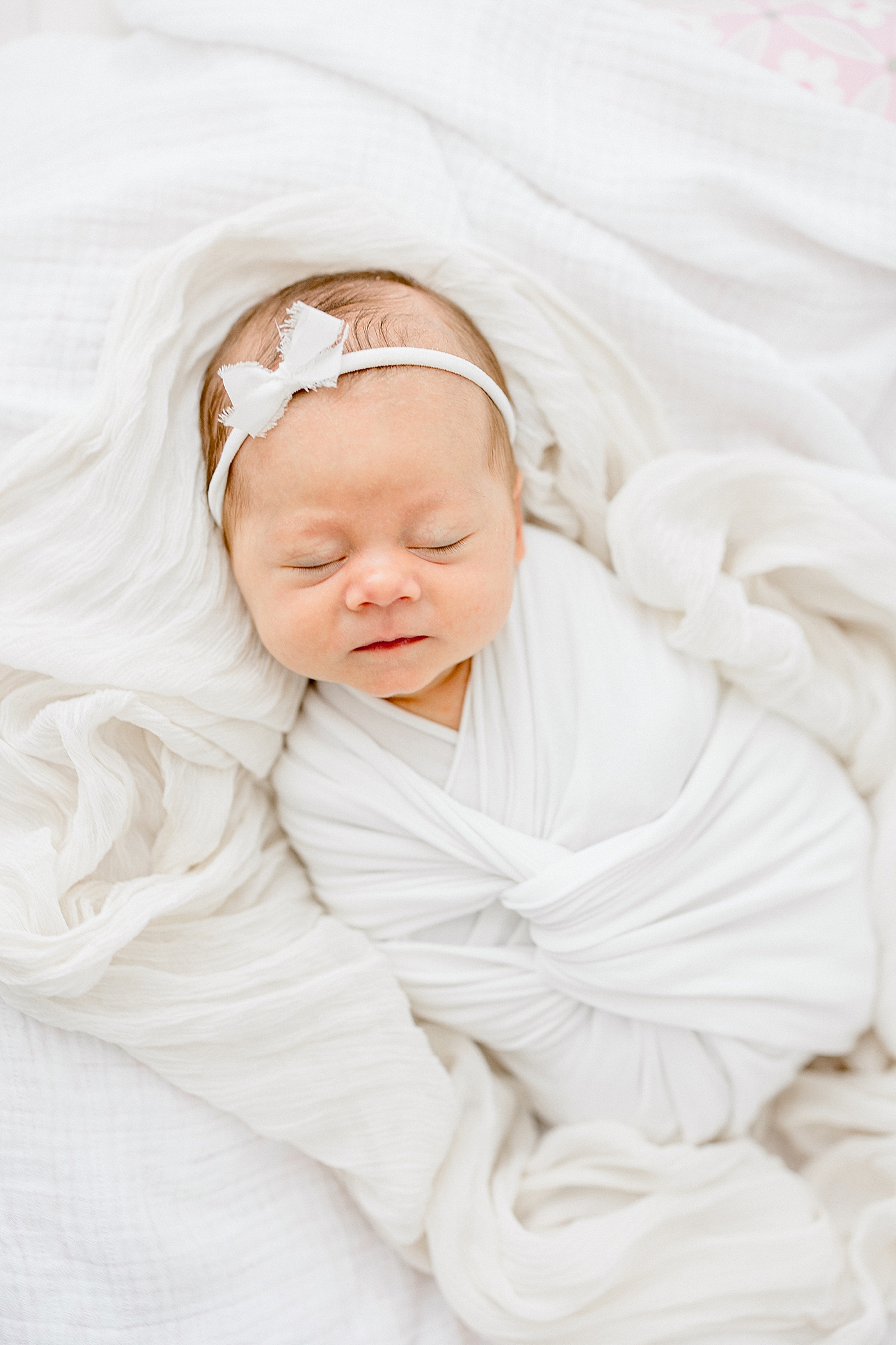 Baby girl swaddled in all white. Photo by Brittany Elise Photography.
