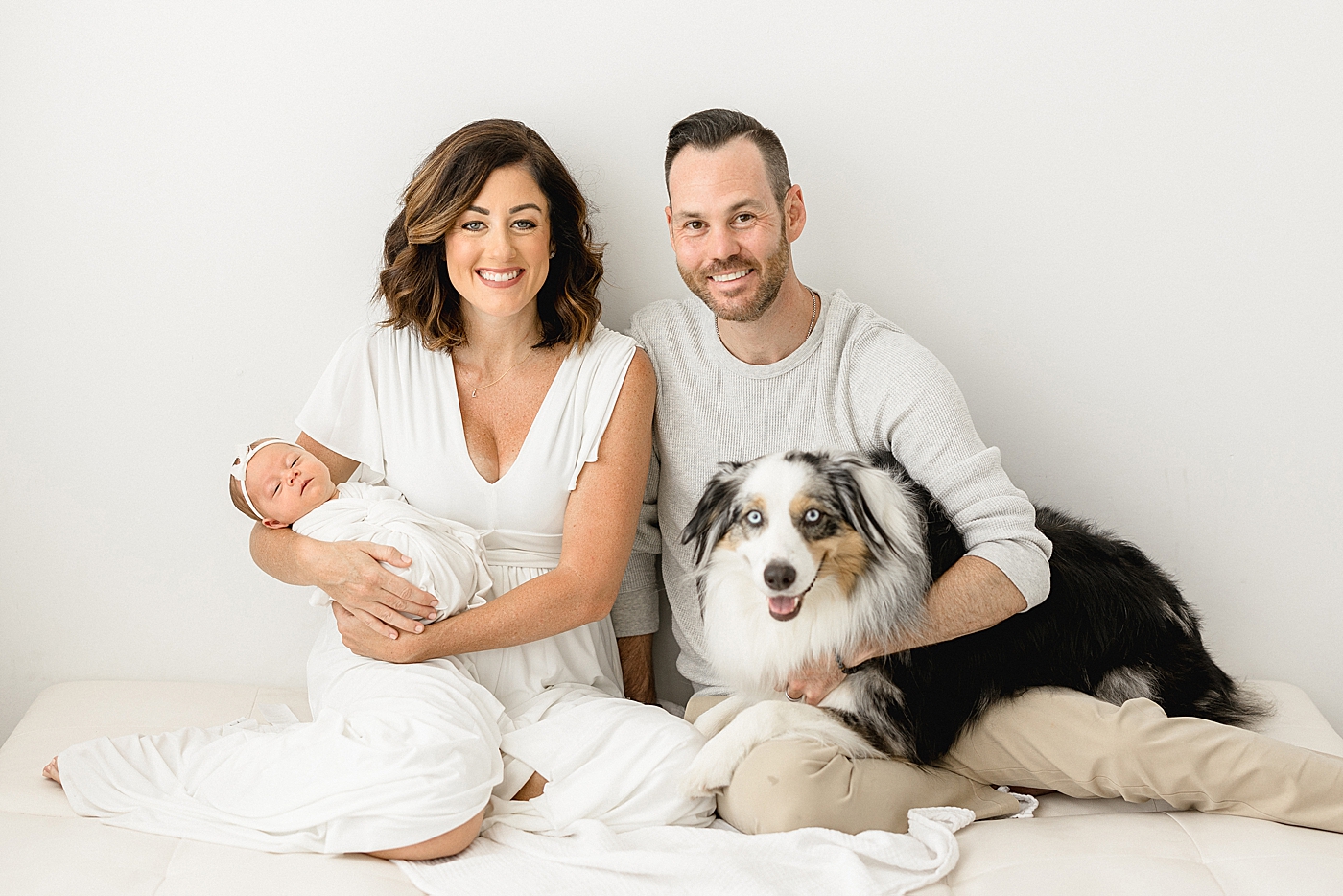 Family portrait with mom, dad, baby girl and their family dog. Photo by Brittany Elise Photography.