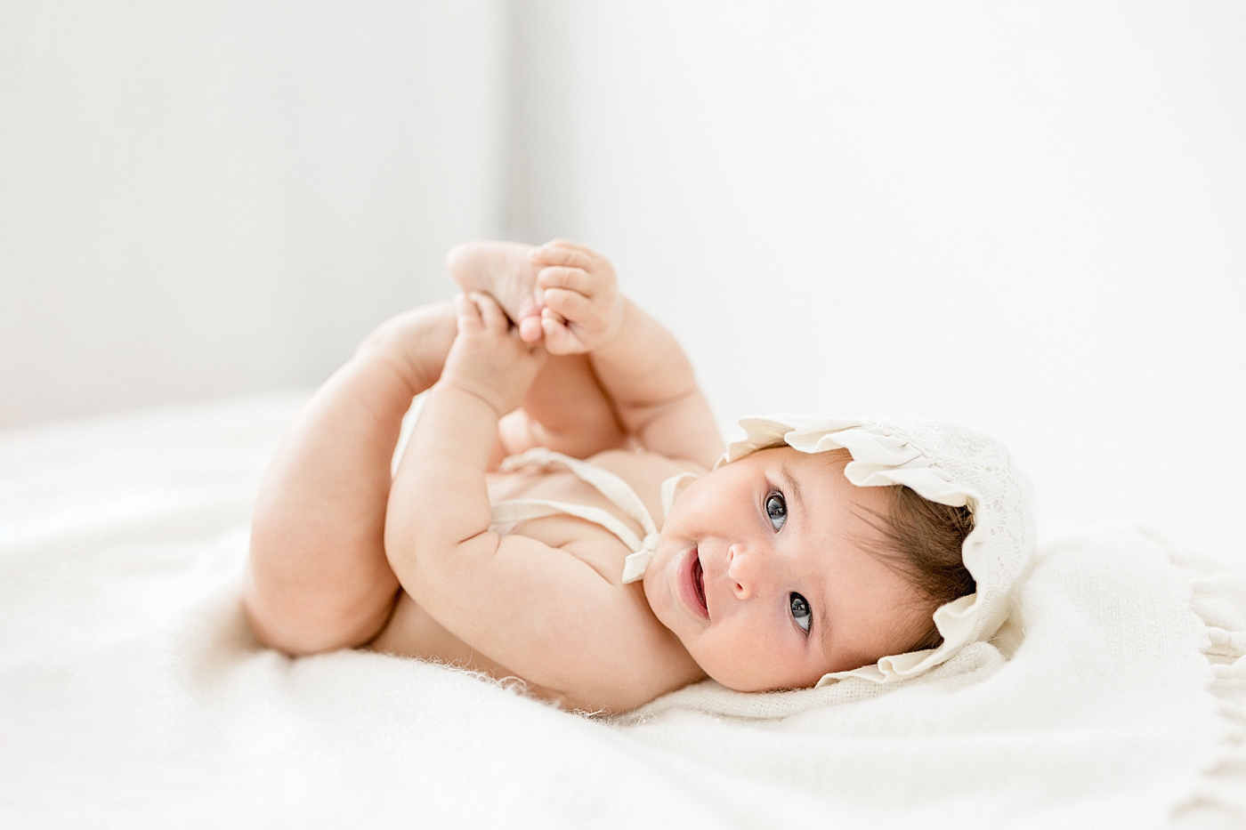 Six month old milestone session with baby girl in a bonnet. Photos by Brittany Elise Photography.