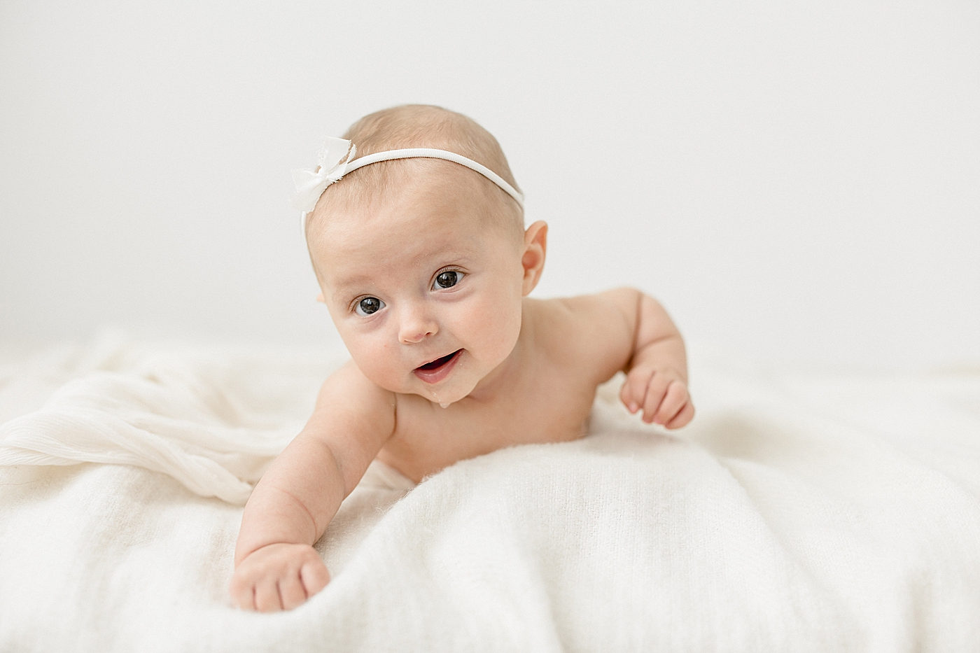 3 month old baby girl pushing up on arms and drooling. Photo by Brittany Elise Photography.