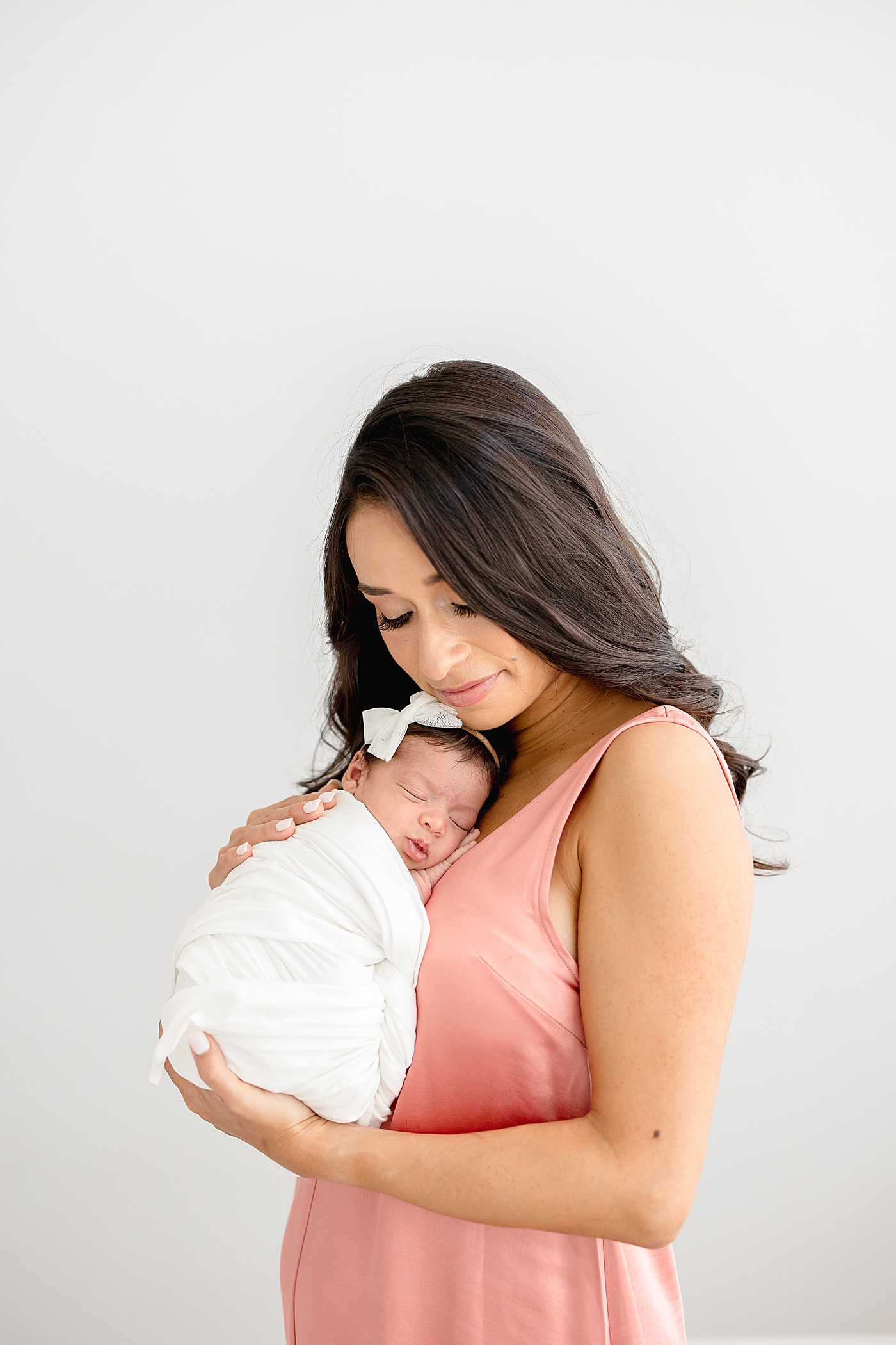 Mom holding her baby girl on her chest. Photo by Brittany Elise Photography.