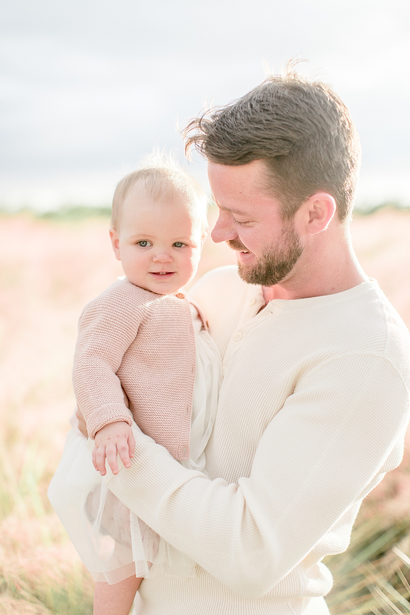 Dad holding his baby girl looking at her. Photo by Brittany Elise Photography.