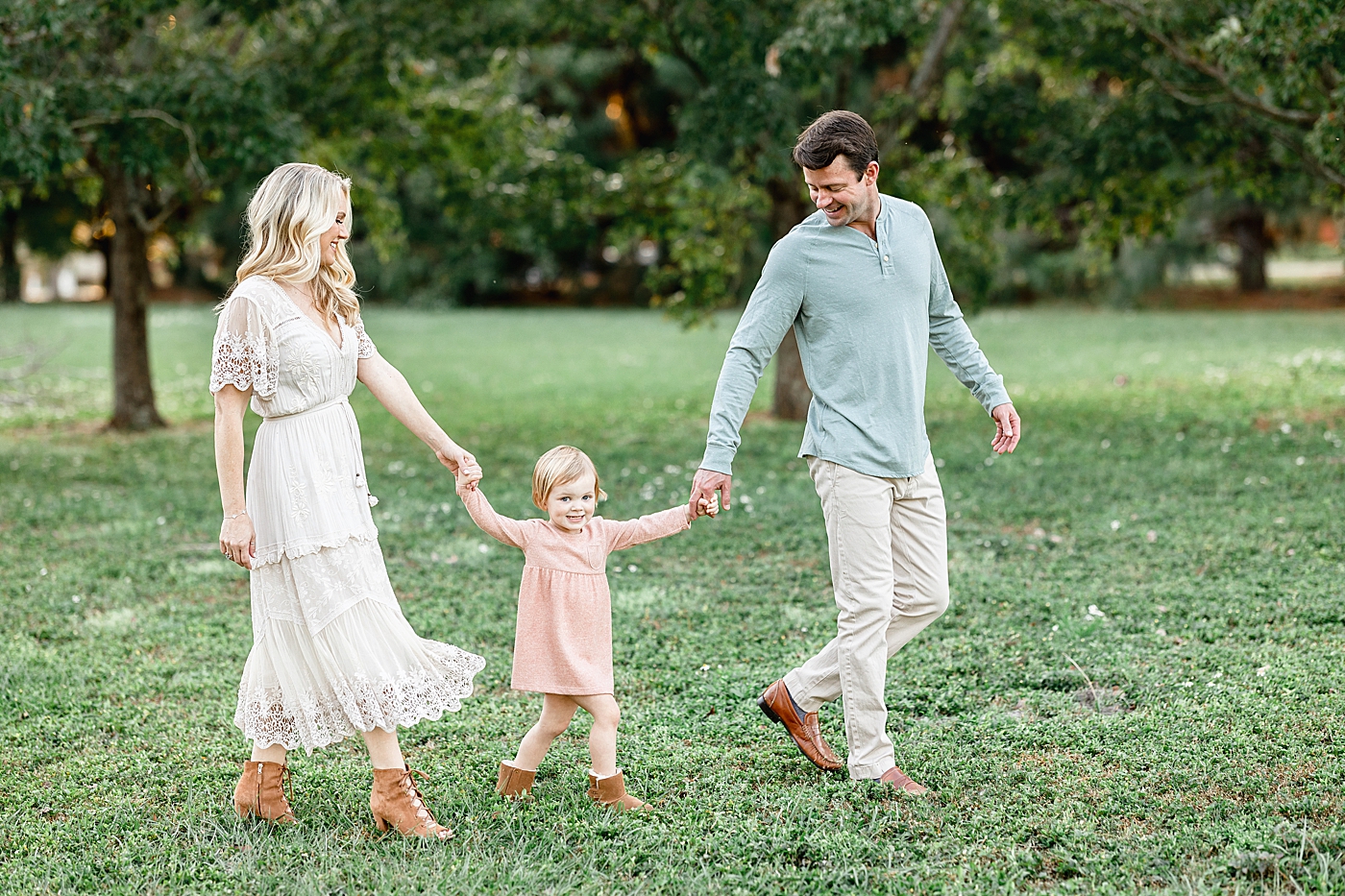 Family of three walking through the field. Photo by Brittany Elise Photography.