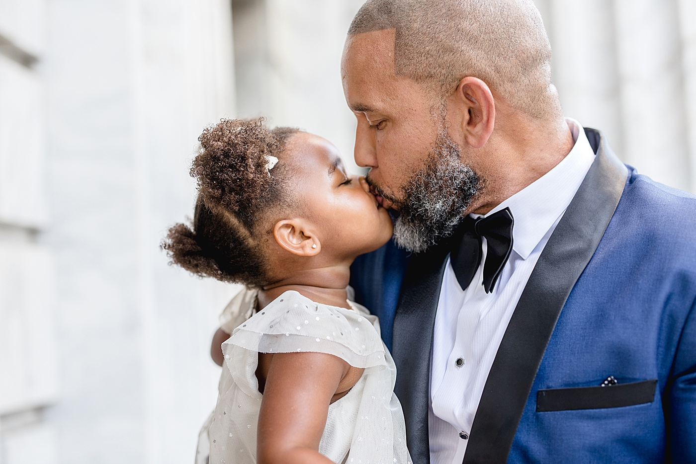 Dad giving two year old daughter a kiss. Photos by Brittany Elise Photography.