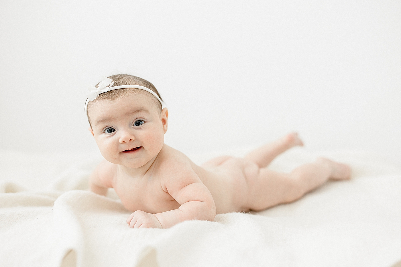 Baby girl laying on her belly bare bum at three month session. Photo by Brittany Elise Photography.