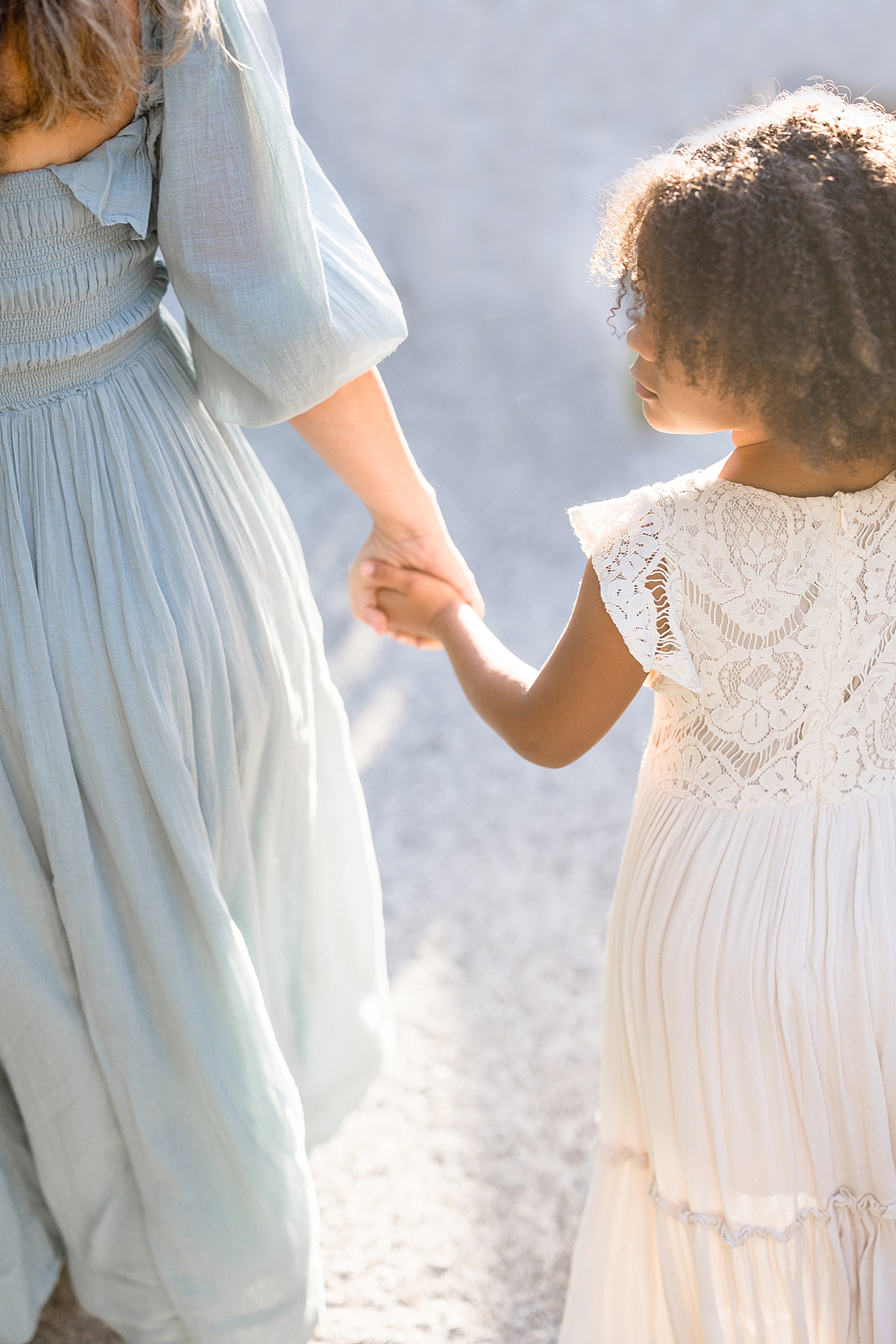 Mom and daughter walking and holding hands. Photo by Brittany Elise Photography.